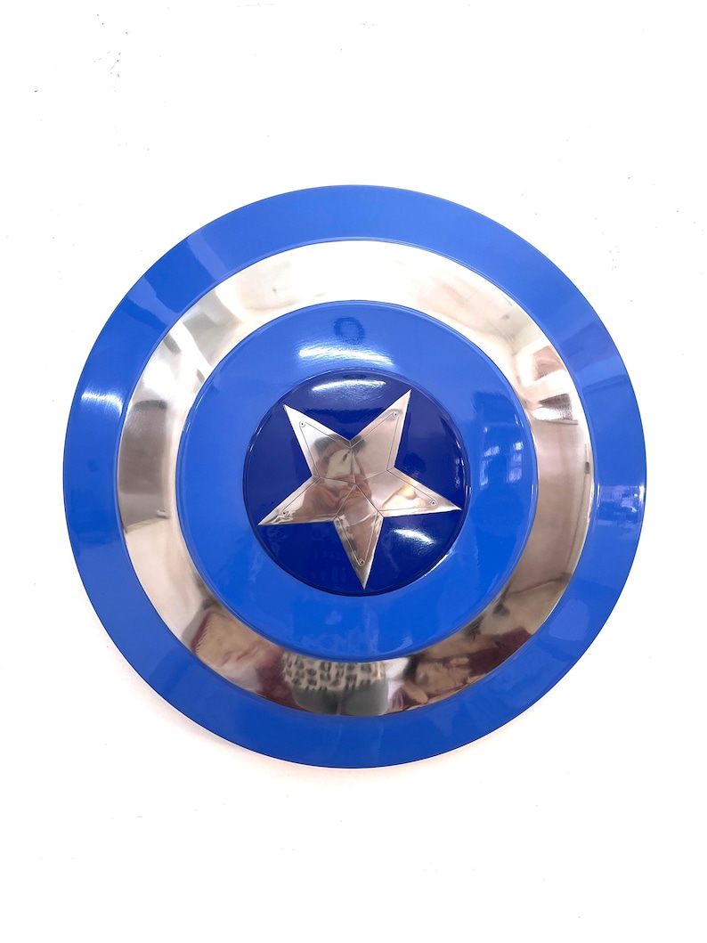Puede incluir: Un escudo redondo azul y plateado con una estrella plateada central. El escudo tiene un acabado brillante y un dise&ntilde;o en capas, con un anillo exterior azul, un anillo central plateado y un centro azul. Una estrella de cinco puntas est&aacute; en el centro.