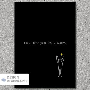 Könnte beinhalten: Schwarze Grußkarte mit dem weißen Text "I LOVE HOW YOUR BRAIN WORKS". Eine Strichmännchenfigur mit erhobenen Armen befindet sich unter einer gelben Glühbirne. Die Karte trägt auch den Text "DESIGN KLAPPKARTE".