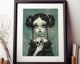 Puede incluir: Impresión artística enmarcada que presenta una ilustración gótica de una niña con ojos grandes sosteniendo una calavera. La niña tiene el pelo negro en coletas y lleva un vestido negro. La impresión se muestra sobre una superficie de madera con el texto "Sample Display • Print is not framed".