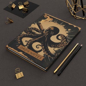 May include: A hardbound journal with a black cover featuring a detailed illustration of an octopus smoking a cigar. The octopus is in shades of brown and black against a gold background. The text "DAD'S NOTES" is printed on a brown label.