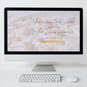 Puede incluir: Una pantalla de ordenador que muestra un fondo blanco con una cita de Proverbios 10:22: "La bendición del Señor es la que enriquece, y no añade tristeza." La cita está escrita en una fuente cursiva con un fondo de acuarela dorado.