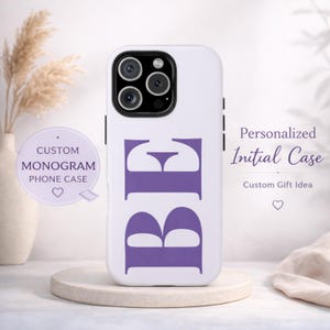 Puede incluir: Funda de teléfono blanca con las letras moradas "BE". La funda está sobre un pedestal blanco. El texto en la funda dice "Personalized Initial Case" y "Custom Gift Idea". Un gráfico circular dice "Custom Monogram Phone Case".
