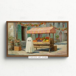 以下が含まれることがあります： フレームに入った絵画で、果物屋台のそばにいる幽霊が描かれています。縞模様のオーニングの下にある屋台には、色とりどりの農産物が並んでいます。このアートワークはヴィンテージ風で、下部に「TIMELESS ART STORE」という文字があります。