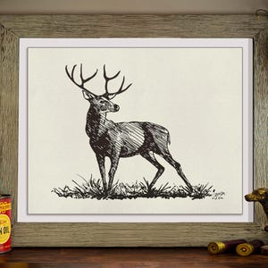 May include: Black and white ink drawing of a stag with large antlers, standing in grass. The artwork is framed in a rustic, light brown wooden frame. The drawing is signed in the bottom right corner.