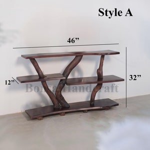 May include: A three-tiered wooden shelf unit with a natural, rustic finish. The shelves are made from reclaimed wood and have a unique, organic shape. The unit is 46 inches wide, 32 inches tall, and 12 inches deep.