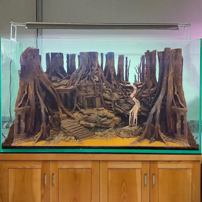 Puede incluir: Un gran acuario con una escena de jungla detallada. La escena incluye una cascada, un camino de piedra y una variedad de plantas y &aacute;rboles. El acuario est&aacute; iluminado por una luminaria fluorescente.