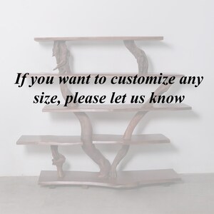 May include: A wooden shelf unit with three shelves, made from natural branches. The shelves are made from wood planks. The text "If you want to customize any size, please let us know" is printed on the white wall behind the shelf unit.