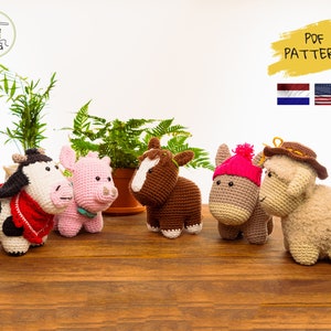 Op de afbeelding: Vijf gehaakte knuffels: een koe, een varken, een paard, een ezel en een schaap. De dieren staan allemaal op een houten oppervlak. De koe draagt een rode bandana. De ezel draagt een roze hoed. Het schaap draagt een bruine cowboyhoed. De dieren kijken allemaal naar de camera. PDF-PATROON.
