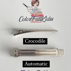 May include: Two silver hair clips. The top clip is a crocodile clip with a serrated edge. The bottom clip is an automatic clip. Both clips are commonly used for hair accessories.