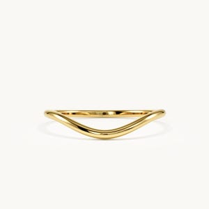 May include: A polished yellow gold ring featuring a smooth, continuous band with a gentle V-shaped curve. The metal has a high-shine, reflective finish that catches the light, creating a sleek and simple design for this solid gold jewelry piece.