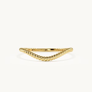 May include: A gold ring featuring a curved, V-shaped band with a twisted rope texture. The metal has a polished, reflective finish, and the design follows a gentle arc, creating a continuous, uniform pattern along the entire length of the band.