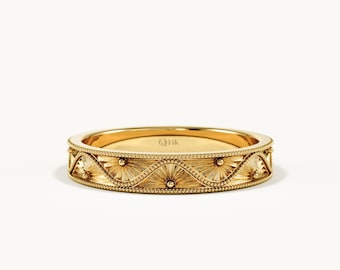 May include: A 14K yellow gold band ring featuring a repeating pattern of engraved sunburst motifs framed by a delicate beaded border. The interior of the band is clearly stamped with the text 14K, indicating the gold purity of the metal.