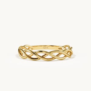 Könnte beinhalten: Ein Ring aus poliertem Gelbgold mit einem komplizierten geflochtenen oder gedrehten Drahtdesign, das das gesamte Band umschließt. Die Innenseite des Rings ist deutlich mit dem Text 14K geprägt, was den Goldgehalt der Metallkonstruktion angibt.