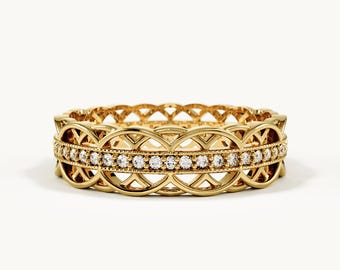 May include: A gold band ring featuring a central row of small, clear, round-cut stones. The band is designed with an openwork, interlocking circular pattern above and below the stone setting, creating a detailed, symmetrical metal structure.