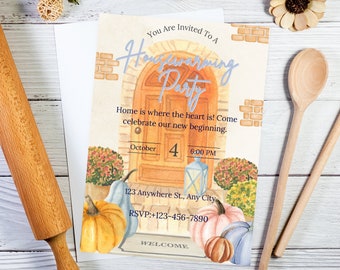 May include: Watercolor housewarming party invitation with a door illustration, pumpkins, and the text "You Are Invited To A Housewarming Party." Includes date, time, and RSVP information. Wooden rolling pin and spoons are in the background.