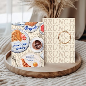 May include: Two brunch-themed invitation cards on a wooden tray. The front card features watercolor illustrations of brunch foods like waffles, bacon, and coffee. The text reads "Brunch" and "Lauren's 30th Birthday". The back card has a repeating "Brunch" pattern.