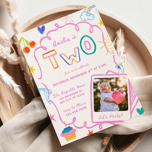 May include: A birthday party invitation with the text "Amelia is TWO" in colorful block letters. The invitation includes a photo of a child holding a pink balloon and the words "Let's Party!" in a pink frame. The invitation is decorated with doodles.
