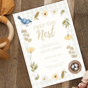 Peut inclure: Une invitation de fête prénatale blanche et bleu clair avec un motif vichy. L'invitation représente un oiseau, un nid avec des œufs et des fleurs. Le texte de l'invitation indique "Préparer le nid" et comprend la date, l'heure et le lieu de la fête.