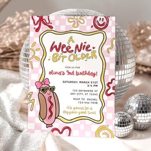 Może przedstawiać: Różowa i biała zaproszenie na urodziny z grafiką hot doga w okularach przeciwsłonecznych. Zaproszenie głosi "A Wee Nie Bit Older" i zawiera szczegóły imprezy. Tło ma wzór w szachownicę i elementy dekoracyjne.