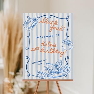 Może przedstawiać: Znak na przyjęcie z niebiesko-białym pasiastym tłem. Znak głosi: "Shuck Yeah! Welcome to Kate's 30th Birthday! September 15th 2025." Znak zawiera ilustracje ostryg i cytryn, na miedzianym stojaku.