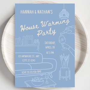 Pode incluir: Um convite azul claro para uma festa de boas-vindas com ilustrações de arte de linha branca. O convite inclui o texto "HANNAH & NATHAN'S House Warming Party" e detalhes do evento. O convite está em um prato de madeira branco.