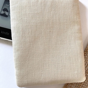 Pu&ograve; includere: Una custodia per e-reader in lino beige con un sottile motivo testurizzato. La custodia &egrave; progettata per proteggere un dispositivo di lettura elettronica.