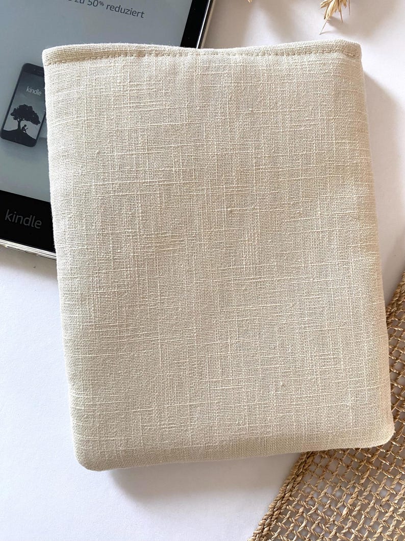 Pu&ograve; includere: Una custodia per e-reader in lino beige con un sottile motivo testurizzato. La custodia &egrave; progettata per proteggere un dispositivo di lettura elettronica.