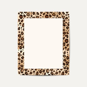 May include: A rectangular picture frame with a leopard print border. The frame has a cream-coloured interior and a border featuring brown and black spots on a tan background. The frame is set against a cream-coloured backdrop.