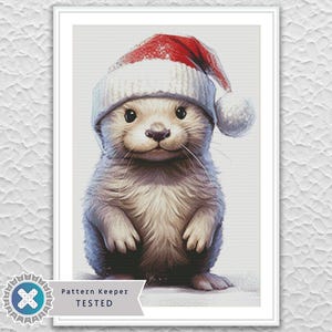 May include: A watercolor illustration of a cute otter wearing a Santa hat. The otter has soft, gray fur and a sweet expression. The hat is white with a red brim and a white pom-pom. The image is framed with a white border.