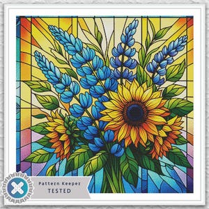 Può includere: Un'opera d'arte in vetro colorato incorniciata con un bouquet di girasoli e fiori blu. L'opera d'arte ha una tavolozza di colori vivaci con tonalità gialle, arancioni, blu e verdi. Il testo "Pattern Keeper TESTED" è visibile in basso a sinistra.