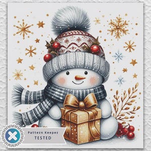 May include: Watercolor illustration of a snowman wearing a gray hat, scarf, and holding a gold gift box. The snowman has a carrot nose and a smiling face. Gold snowflakes and stars decorate the background. The image is labeled "Pattern Keeper TESTED."