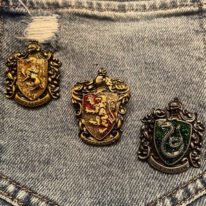 Harry Potter student badge pins. Hogwarts house pins Harry Potter pins. Wizarding world of Harry Potter pins