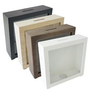 Può includere: Quattro scatole a ombre in legno con facce in vetro. Le scatole sono impilate l'una sull'altra, con la scatola più grande in basso e la scatola più piccola in alto. Le scatole sono nere, in legno naturale, marroni e bianche.