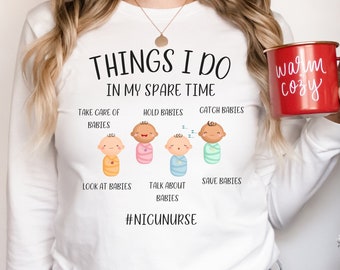 Può includere: Maglietta bianca a maniche lunghe con il testo "THINGS I DO IN MY SPARE TIME" e illustrazioni di bambini. Il testo sotto le illustrazioni dice "TAKE CARE OF BABIES, HOLD BABIES, CATCH BABIES, LOOK AT BABIES, TALK ABOUT BABIES, SAVE BABIES". Il testo in fondo alla maglietta dice "#NIGUNURSE".
