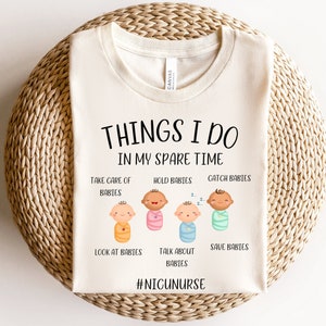 May include: A white t-shirt with the text "Things I do in my spare time" and illustrations of babies. The text below the illustrations includes "Take care of babies, Hold babies, Catch babies, Look at babies, Talk about babies, Save babies". The bottom of the shirt has the text "#NICUNURSE".