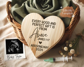 May include: A heart-shaped wooden plaque inscribed with "EVERY GOOD AND PERFECT GIFT IS FROM Above JAMES 1:17 ARRIVING MAY 2024" sits in a wicker basket with a green cloth. A sonogram photo and syringe are also present.