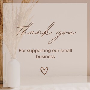 May include: A thank you message with a heart symbol, written in brown cursive script on a light beige background. The text reads "Thank you for supporting our small business". A vase with dried pampas grass is in the left corner of the image.