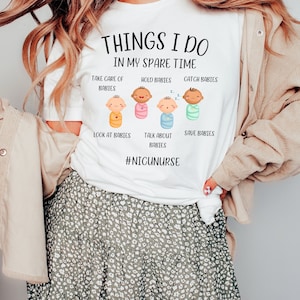 May include: White t-shirt with the text "Things I do in my spare time" and a graphic of five babies in swaddles. The text below the graphic reads "Take care of babies, hold babies, catch babies, look at babies, talk about babies, save babies." The bottom of the shirt has the hashtag "#NICUNURSE".