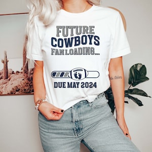 Puede incluir: Camiseta blanca con el texto "Future Cowboys Fan Loading..." y una barra de progreso con un bal&oacute;n de f&uacute;tbol y huellas de pies de beb&eacute;. La barra de progreso indica "Due May 2024".