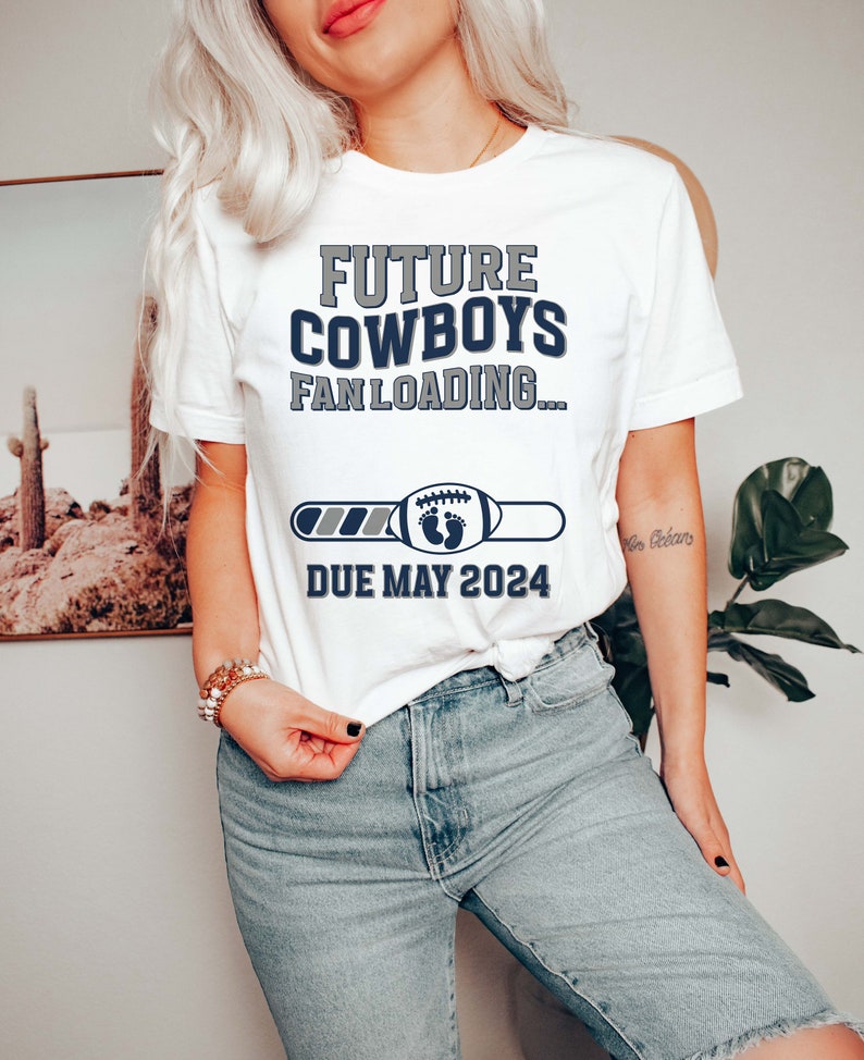 Puede incluir: Camiseta blanca con el texto "Future Cowboys Fan Loading..." y una barra de progreso con un bal&oacute;n de f&uacute;tbol y huellas de pies de beb&eacute;. La barra de progreso indica "Due May 2024".