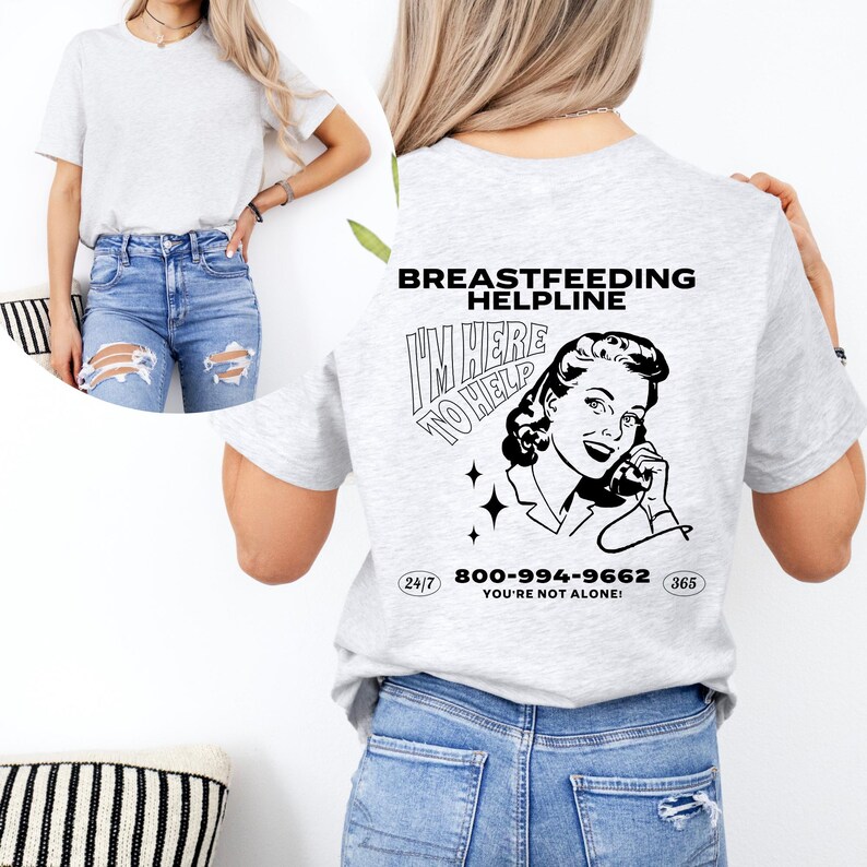 May include: A grey t-shirt with a black and white illustration of a woman on the phone. The text "Breastfeeding Helpline" and "I'm Here To Help" are printed on the shirt. The phone number 800-994-9662 is printed below the illustration. The text "24/7" and "365" are printed on either side of the phone number. The text "You're Not Alone!" is printed below the phone number.