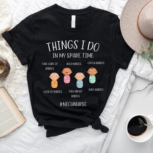 May include: Black t-shirt with white text that reads "Things I do in my spare time."  The text is surrounded by illustrations of babies in different poses.  The text "#NICUNURSE" is at the bottom of the shirt.