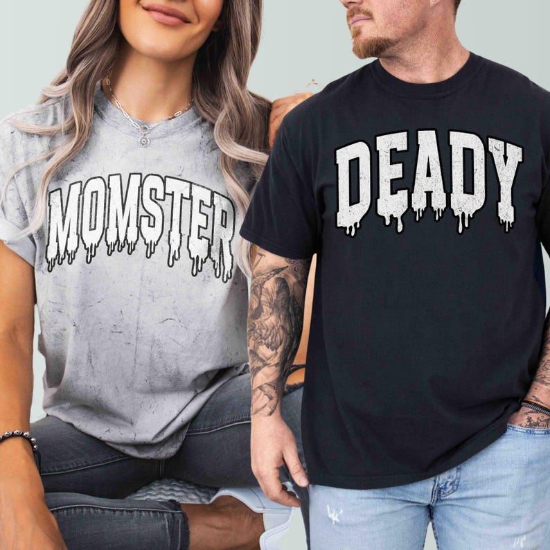 May include: Two t-shirts with a Halloween theme. The white t-shirt has the text "MOMSTER" in black with dripping paint. The black t-shirt has the text "DEADLY" in white with dripping paint.