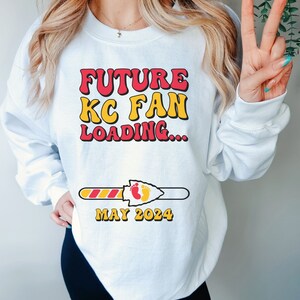 May include: White sweatshirt with a red and yellow graphic that says "FUTURE KC FAN LOADING..." with a progress bar that says "MAY 2024".