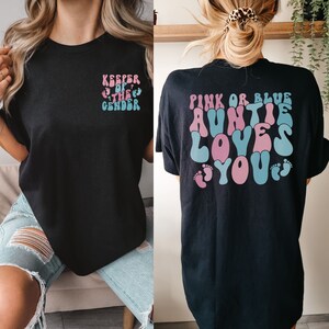 women wearing keeper of the gender shirt that says "pink or blue auntie loves you" on the back and "keeper of the gender" on the front pocket of theshirt.