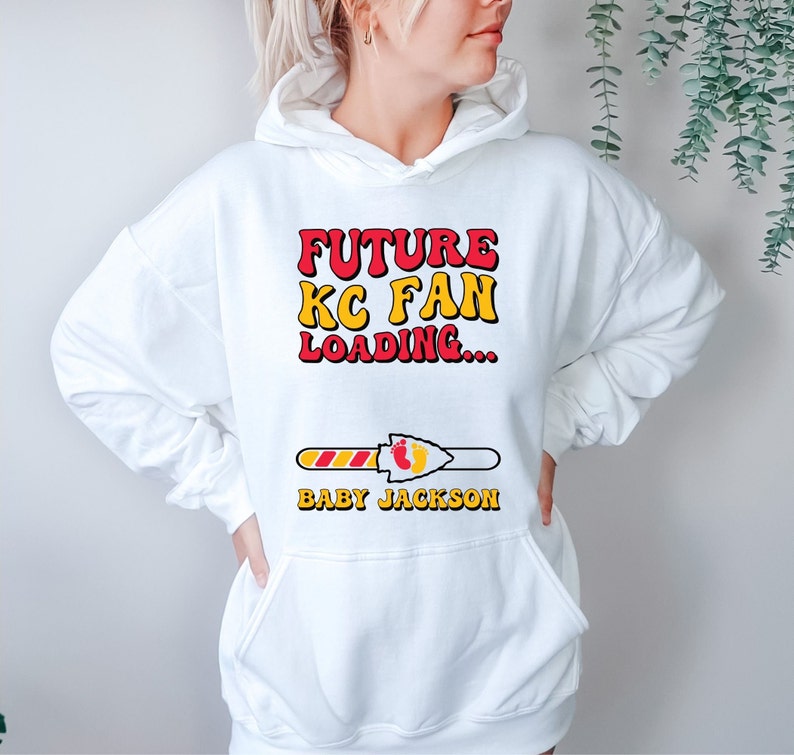 May include: White hoodie with a red and yellow graphic that says "Future KC Fan Loading..." with a progress bar and the text "Baby Jackson".