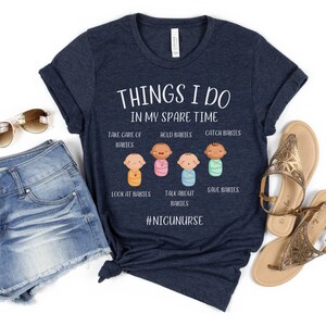May include: A navy blue t-shirt with the text "THINGS I DO IN MY SPARE TIME" and a graphic of five baby figures with the text "TAKE CARE OF BABIES", "HOLD BABIES", "CATCH BABIES", "LOOK AT BABIES", "TALK ABOUT BABIES", "SAVE BABIES" and the hashtag "#NIGUNURSE".