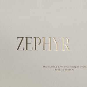 May include: A light beige surface featuring the word ZEPHYR in large, metallic gold serif capital letters. Below the main text, smaller gold text reads: Showcasing how your designs could look in print <3. The overall aesthetic is clean and professional.