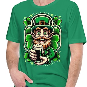 May include: A green t-shirt featuring a cartoon illustration of a leprechaun holding a glass of beer. The leprechaun is wearing a green hat and has a red beard. The illustration is surrounded by shamrocks.