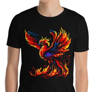 May include: A black t-shirt featuring a pixelated image of a phoenix rising from flames. The phoenix is red, orange and yellow with blue accents.